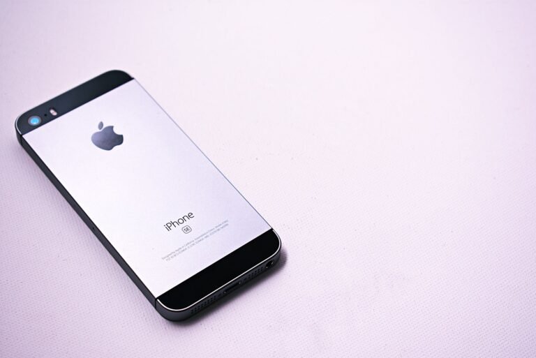 A sleek and modern smartphone placed on a minimalistic light surface, showcasing its design.