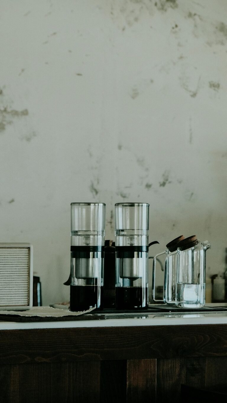Modern coffee brewing equipment on a cafe table with a rustic backdrop.